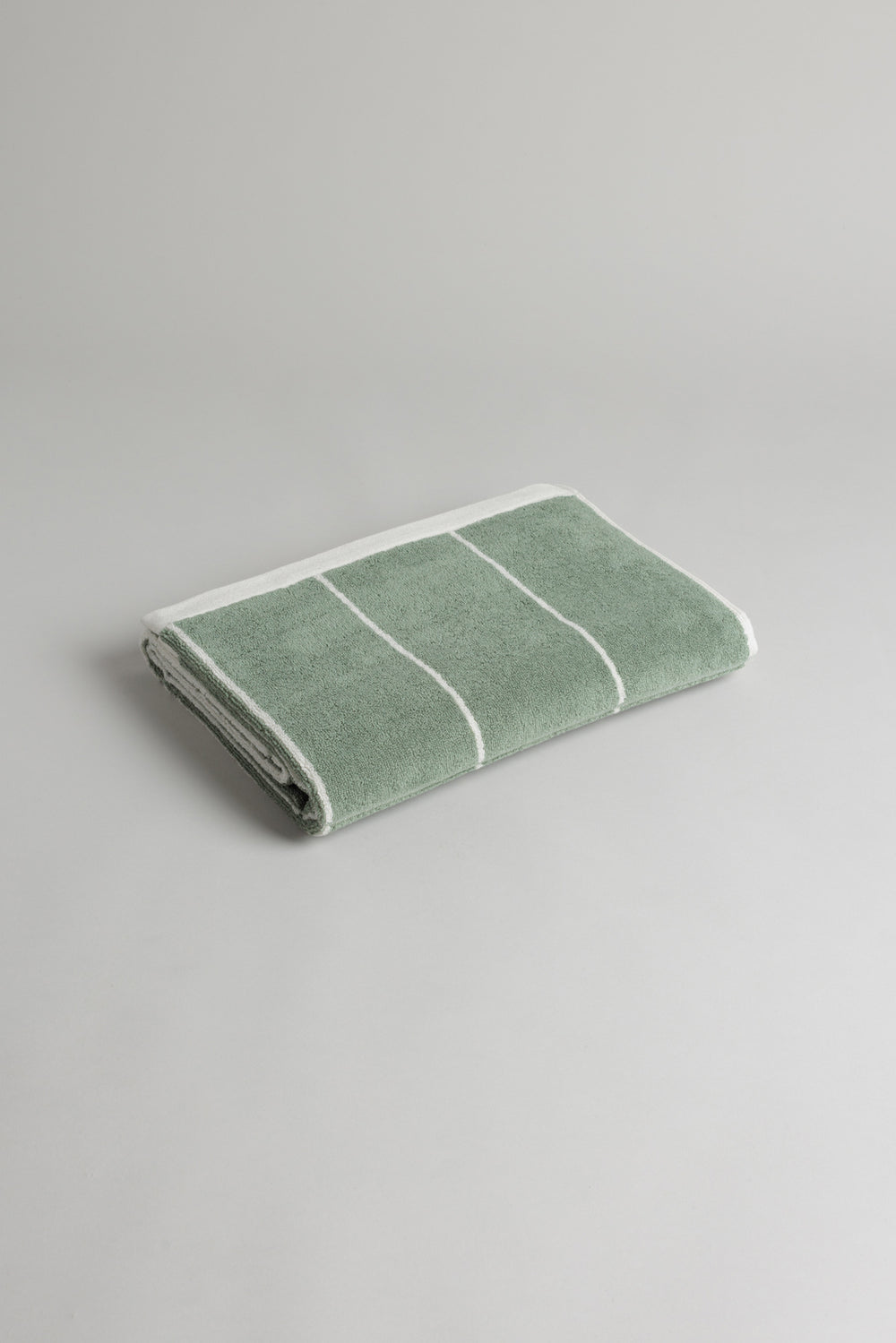 Soft BAINA Bethell bath towel in sage and chalk, showcasing its plush texture and vibrant color accents.