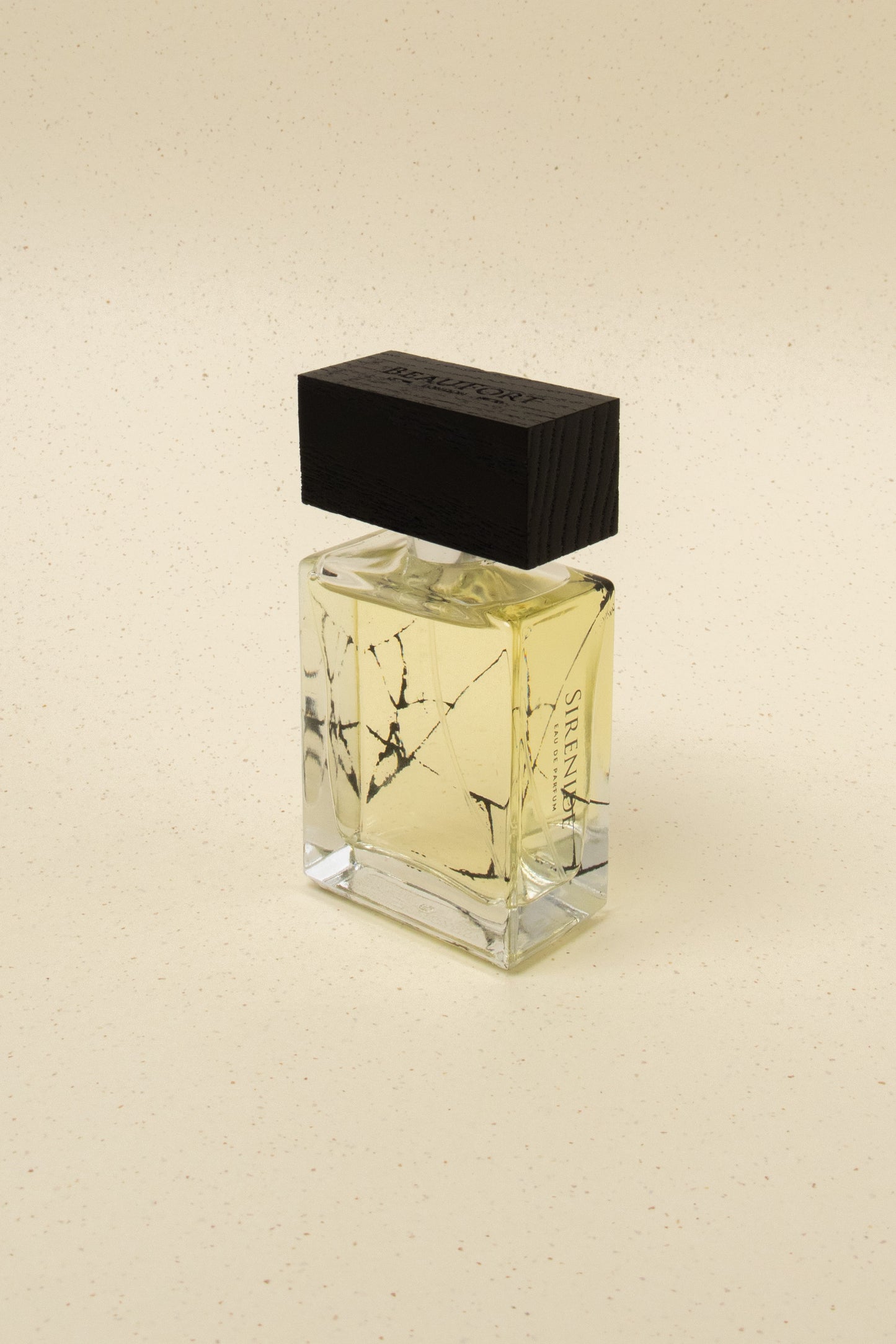 BeauFort London Siren niche perfume bottle with black wooden cap on beige speckled background