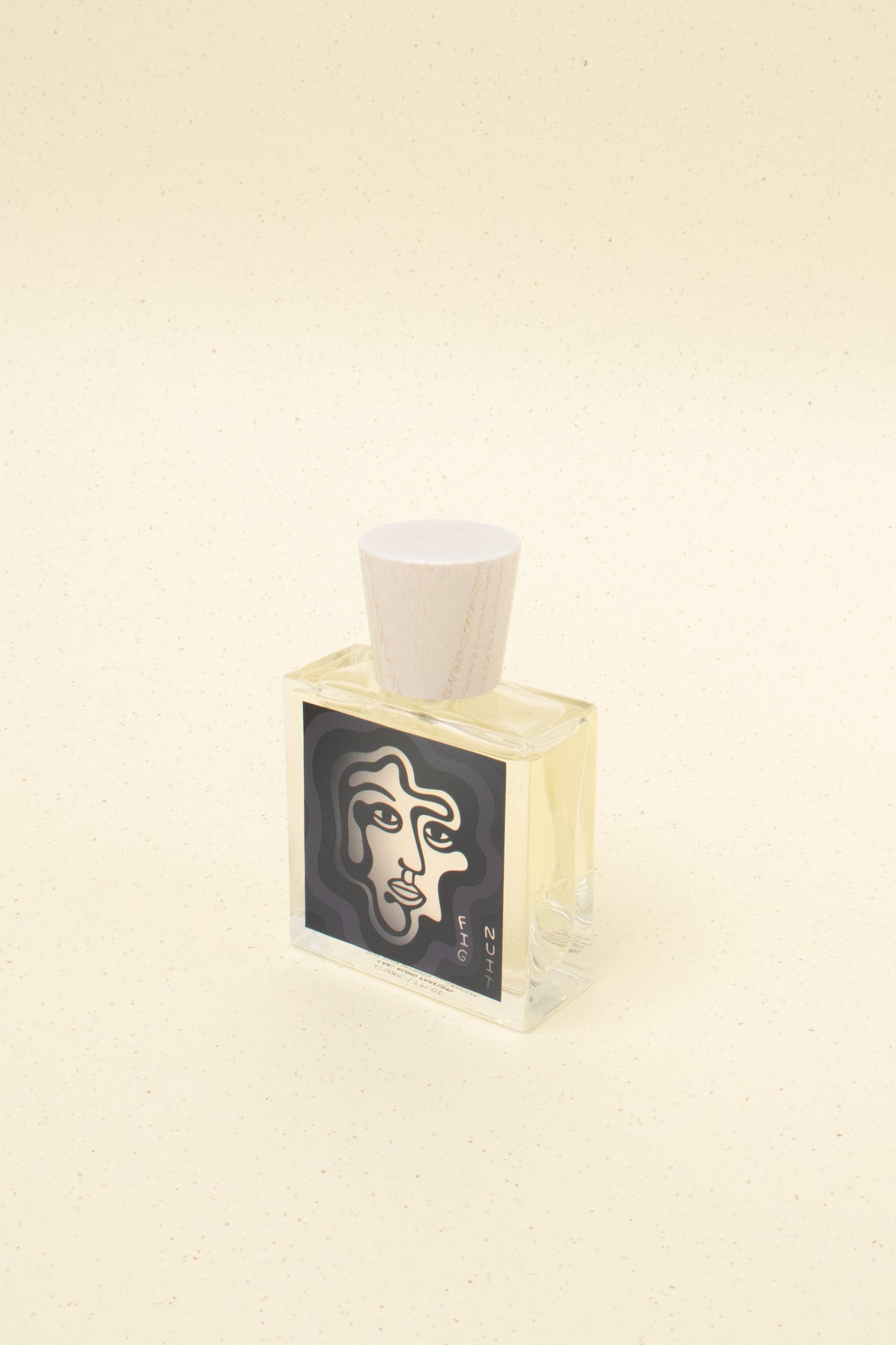 Minimalist perfume bottle with wooden cap and abstract face label on light beige background