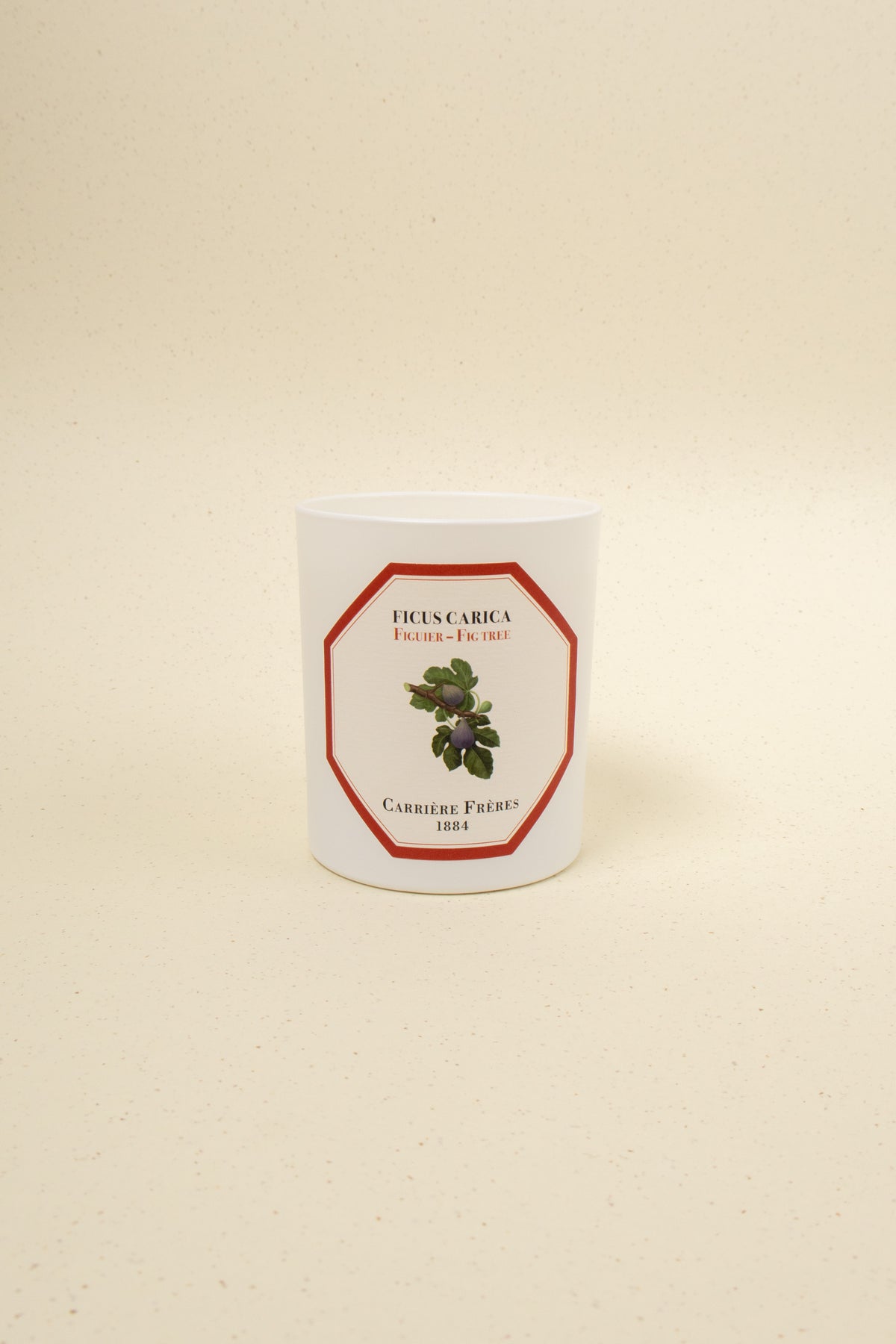 Carrière Frères Fig Tree scented candle with a simple glass holder and a burning wick, emitting a warm, inviting glow.
