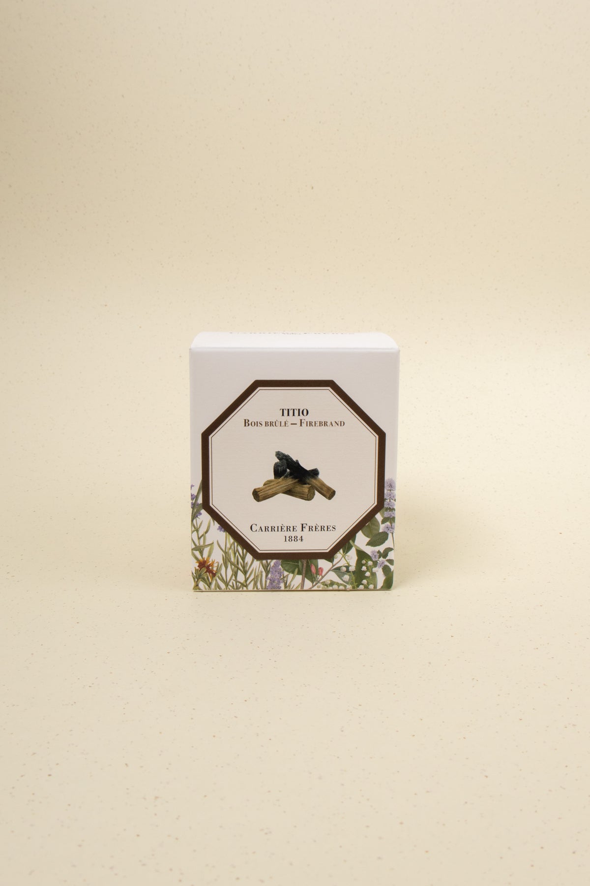 Carrière Frères Firebrand scented candle in a glass jar with a lit wick and warm glow, showcasing its elegant design.