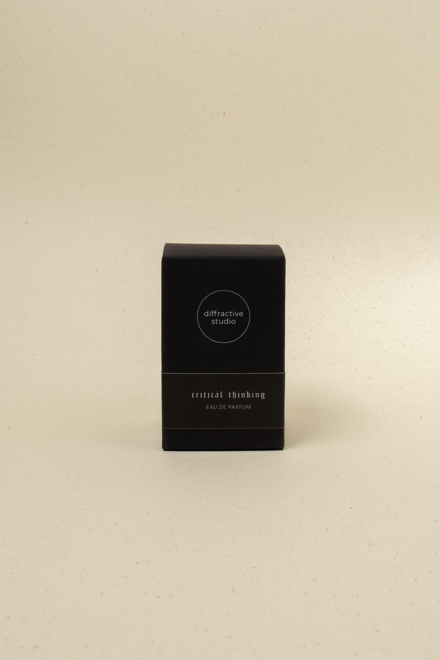 Diffraction Studio Critical Thinking perfume bottle with sleek black and silver design, showcasing modern packaging.