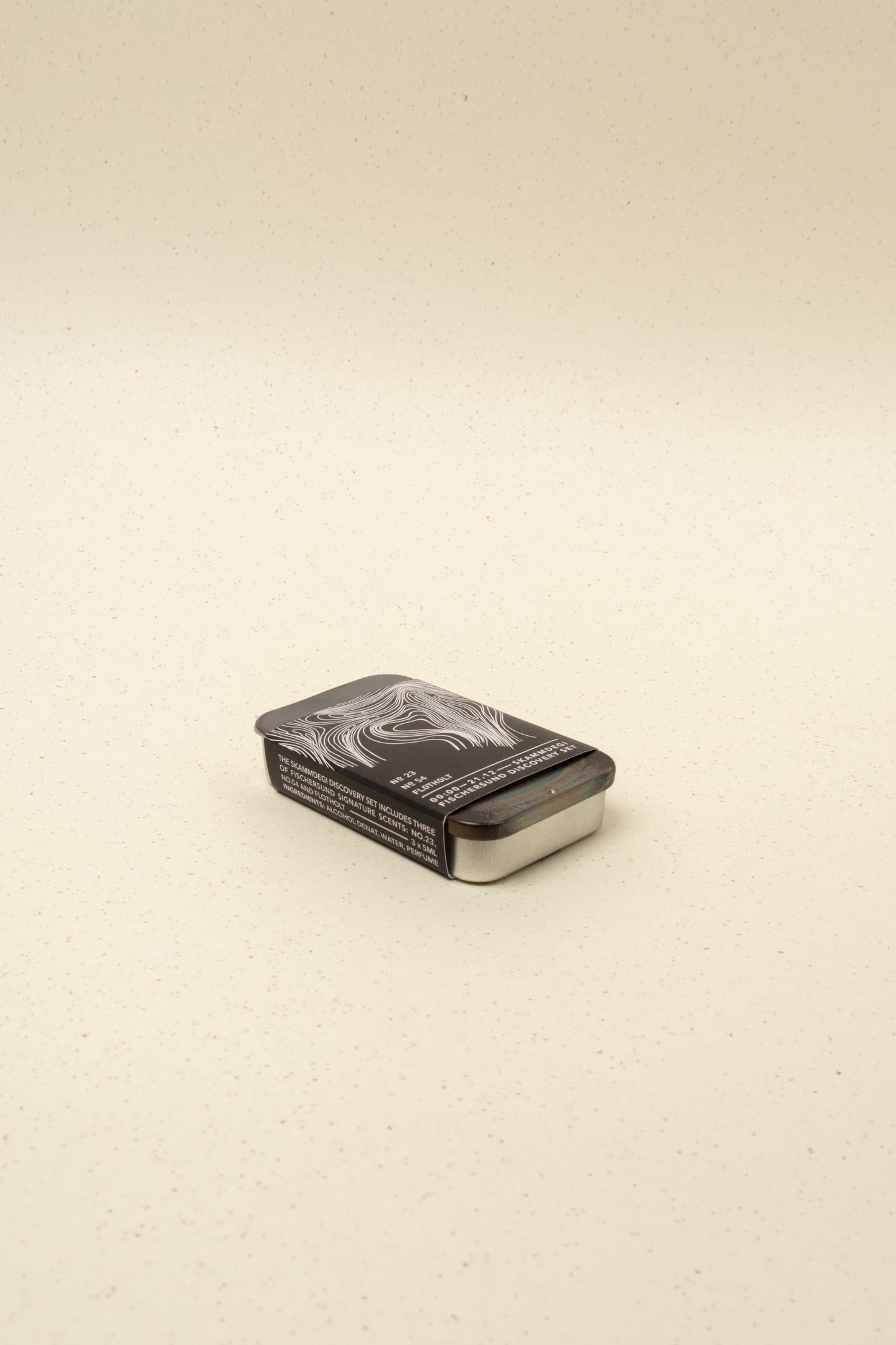 Fischersund Skammdegi scented perfume discovery set in a minimalist container on a beige speckled surface