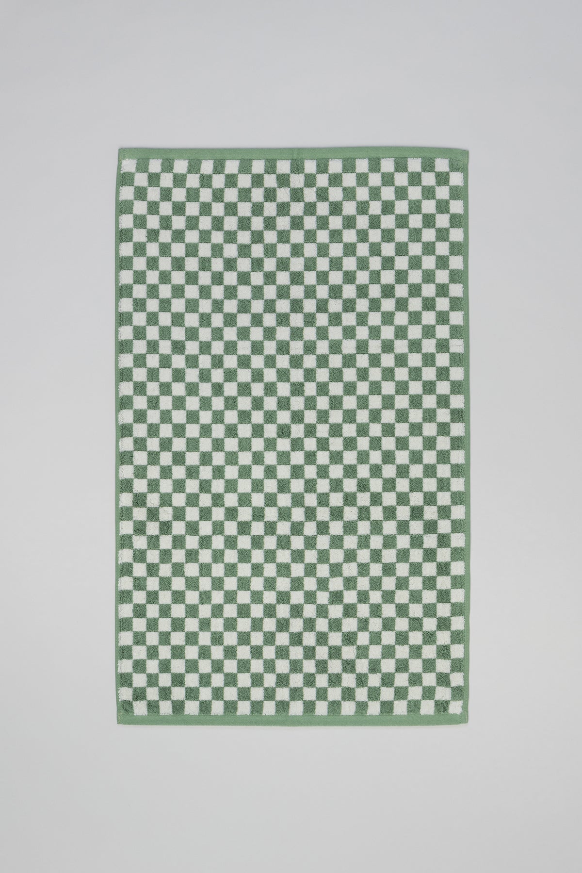 Baina Beppu bath mat in sage and chalk colors, soft textured fabric, displayed flat on a white surface for bathroom decor.