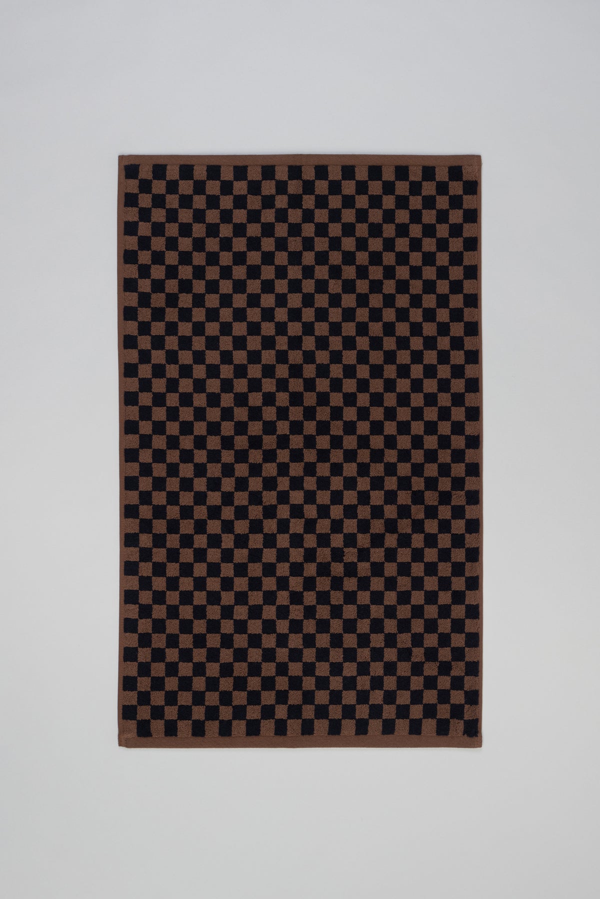 Beppu bath mat in Tabac and Noir by BAINA, showing a soft, plush bath rug with a stylish two-tone design.