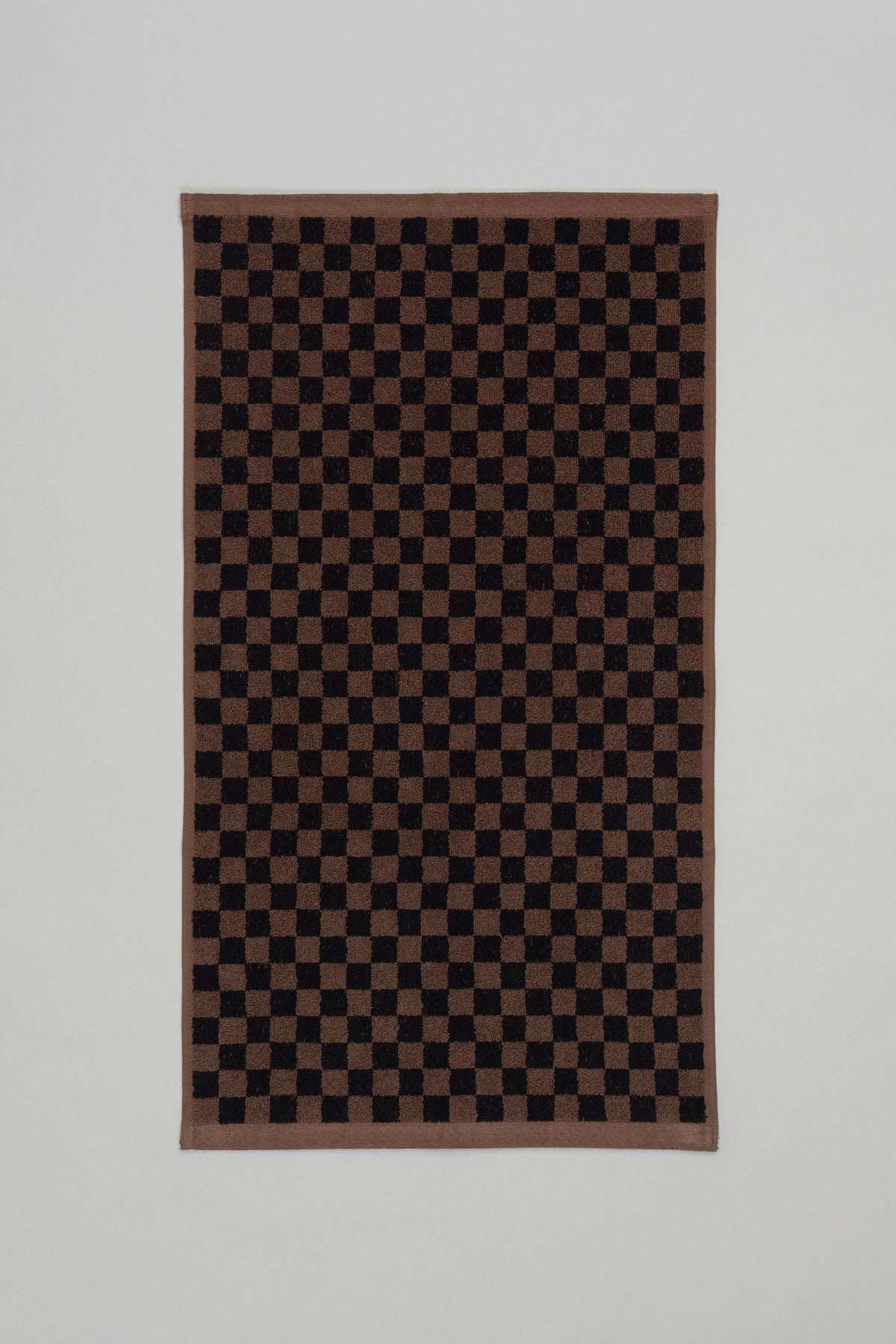 Baina Josephine hand towel in Tabac and Noir, flatlay showing soft, woven fabric with elegant striped design.