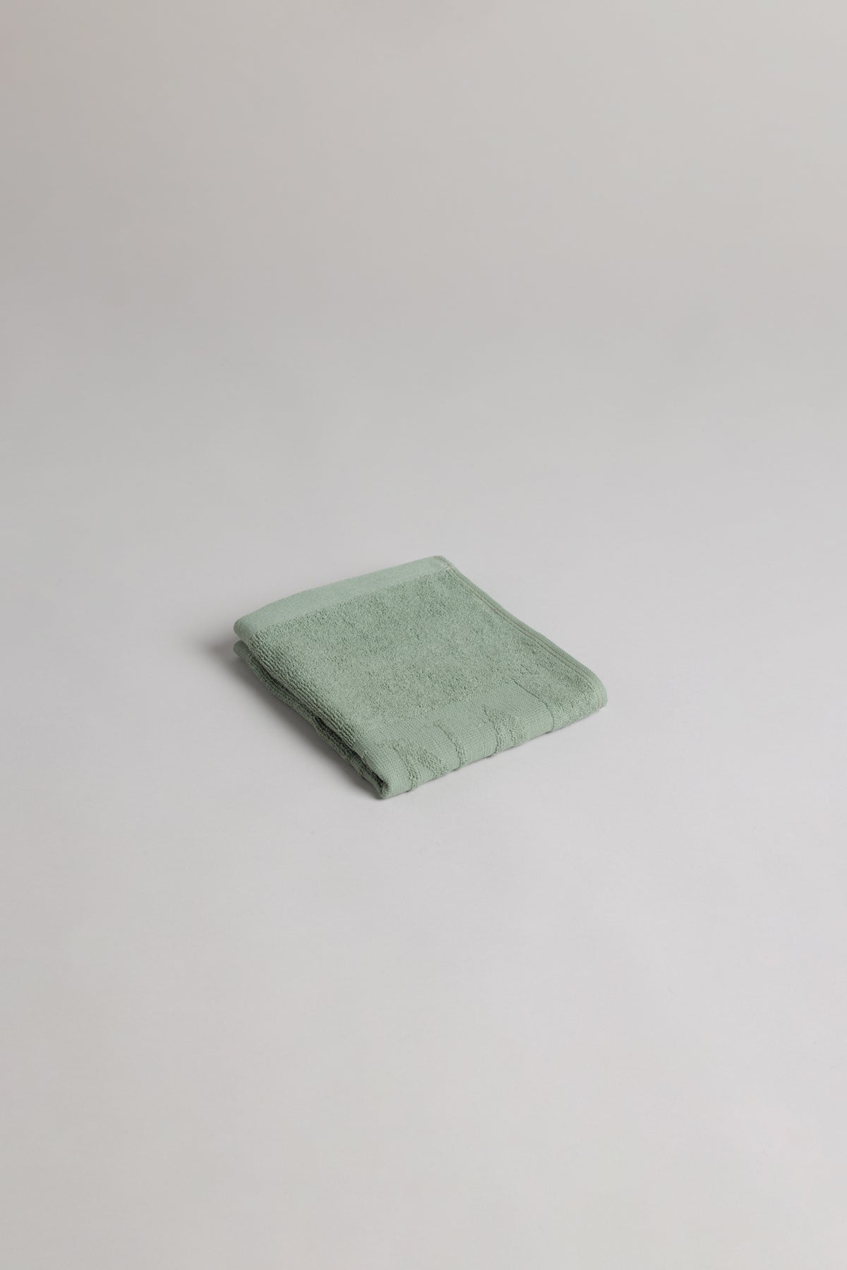 BAINA Agnes face cloth in sage, soft and folded for gentle cleansing, made from plush, absorbent fabric for skincare.