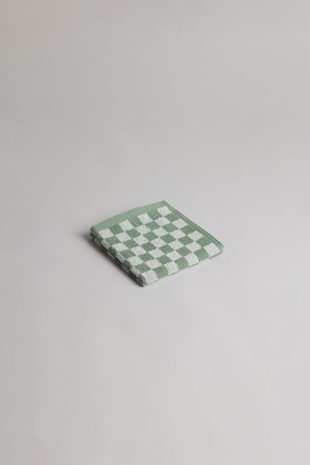 Baina Quill face cloth in sage and chalk, folded, soft cotton washcloth for gentle skincare and facial cleansing.