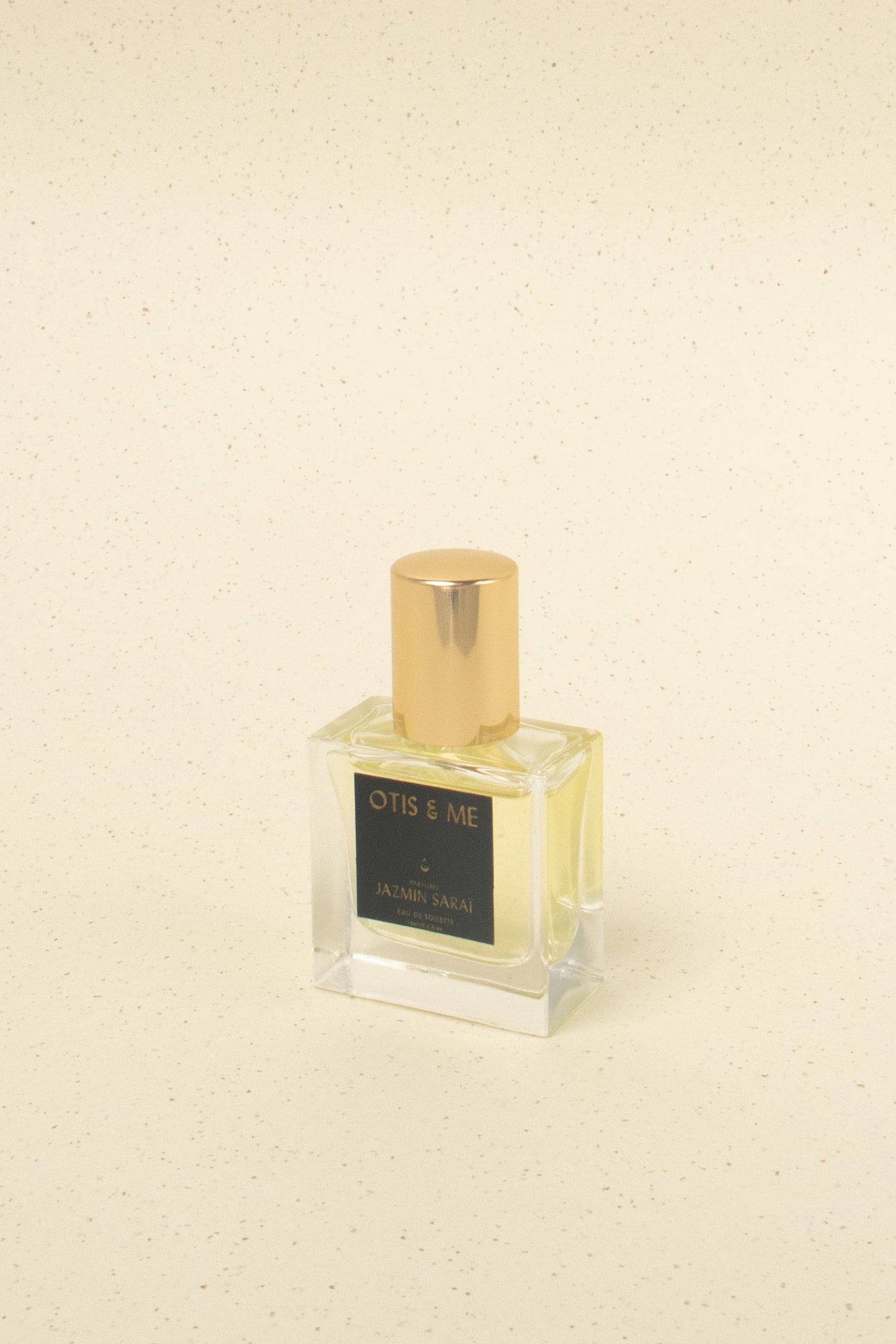 Otis & Me Jazmin Sarai eau de toilette niche perfume bottle with gold cap on beige speckled background