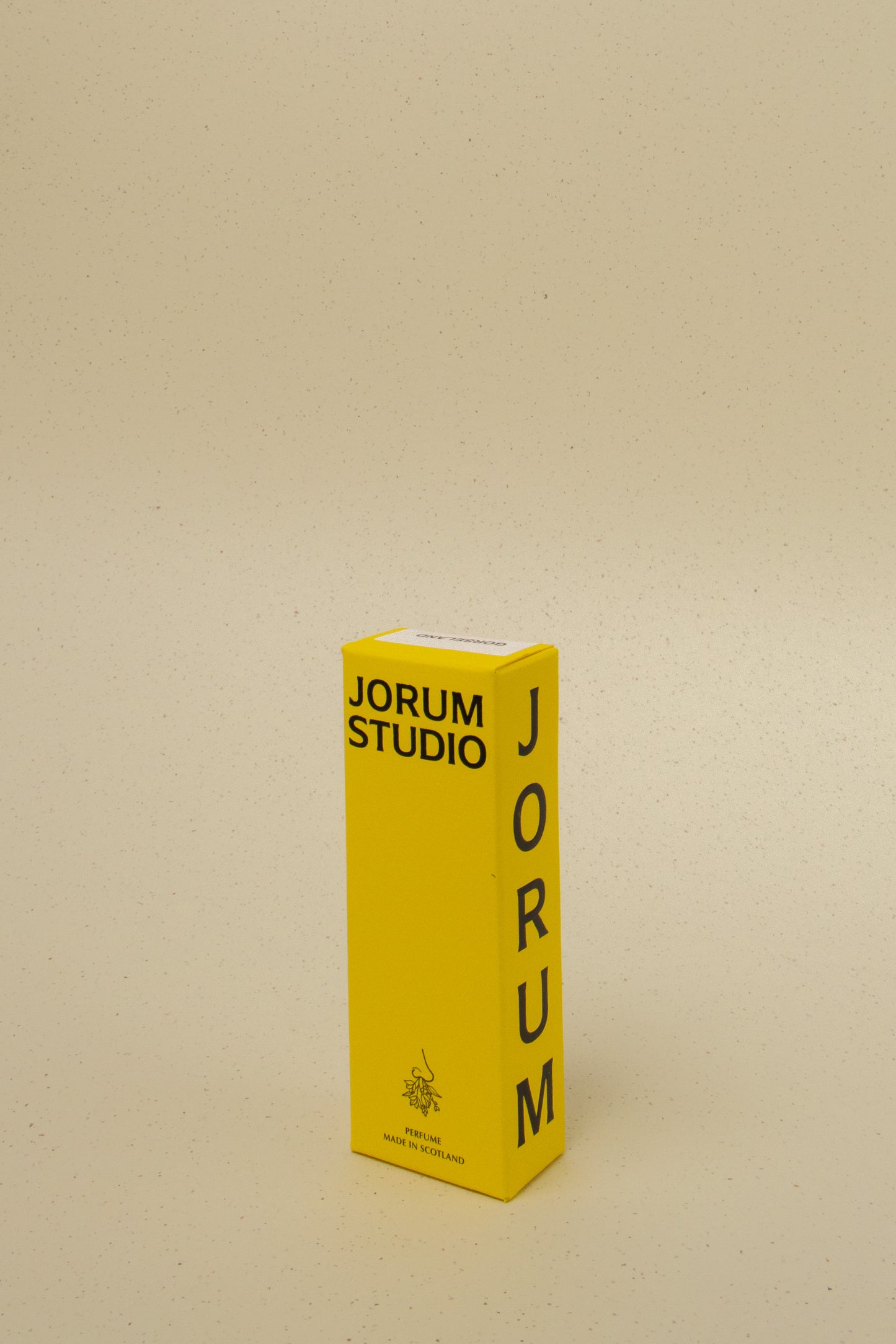 Bright yellow Jorum Studio perfume box with black text on beige speckled background