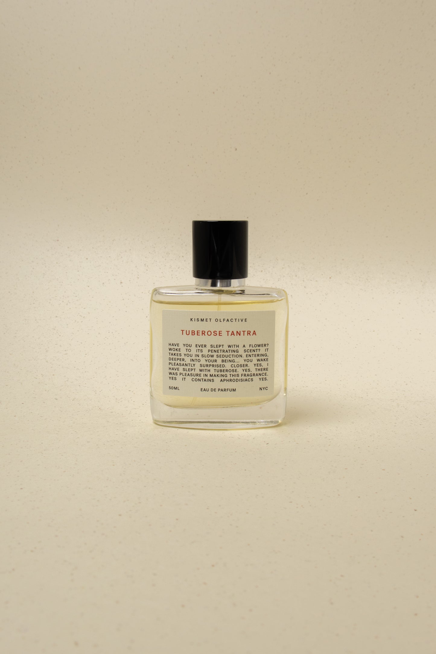 Kismet Olfactive Tuberose Tantra perfume bottle with black cap on beige speckled background, 50ml Eau de Parfum