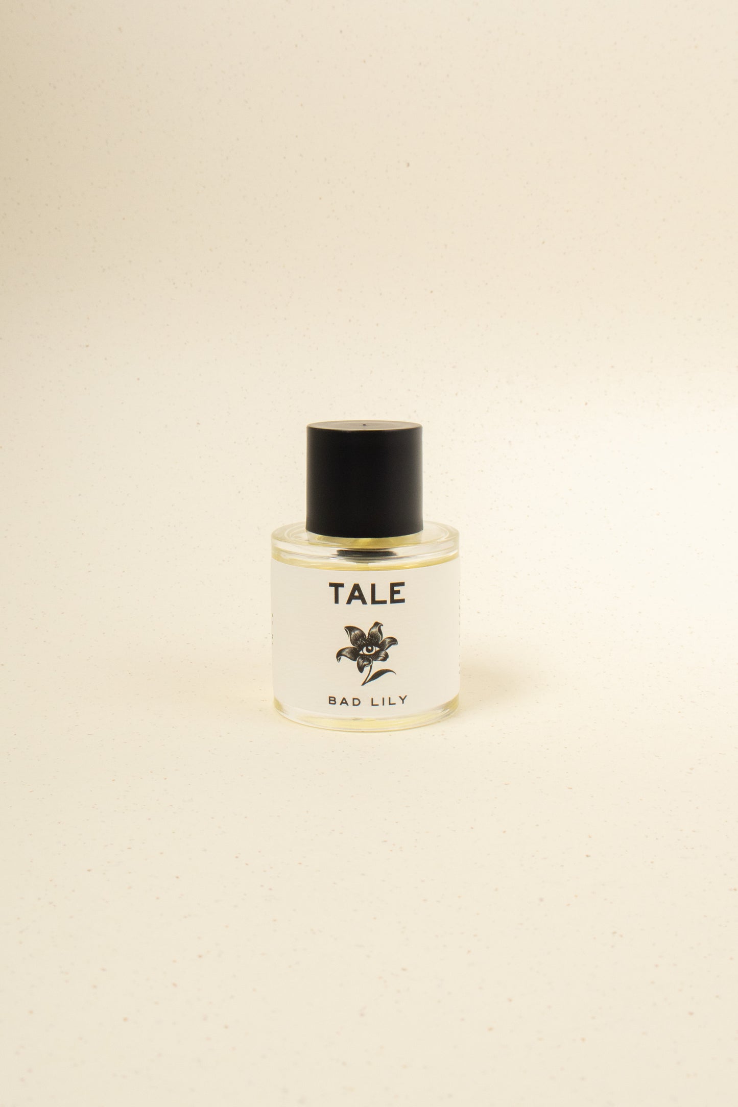 TALE Bad Lily perfume bottle with a sleek design, featuring a clear glass container and white cap, on a neutral background.
